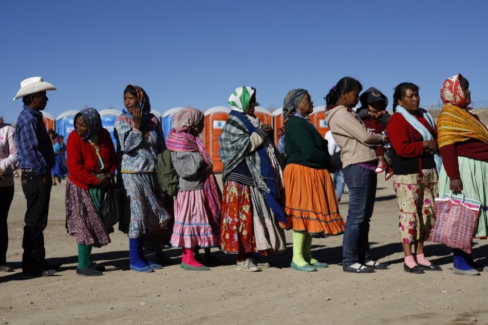 Tarahumara Indians stand in line to receive a government donation of food in Guachochi