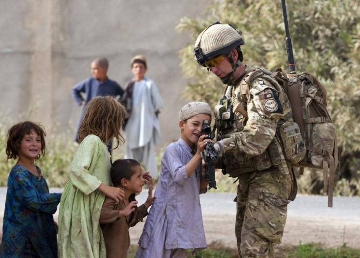 A British Army Major shows his rifle to Afghan children during a patrol outside Checkpoint Tander near Lashkar Gah in Helmand province
