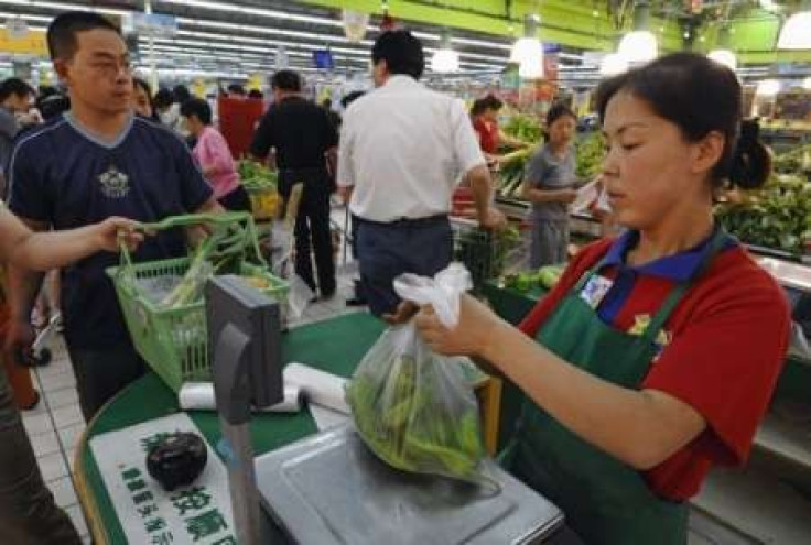 A staff member packs a customer's items into a plastic bag at a supermarket in Changzhi, Shanxi province 
