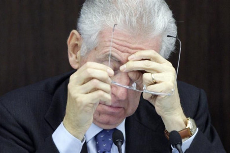 Italian Prime Minister Monti takes his glasses during a news conference on the new austerity package in Rome