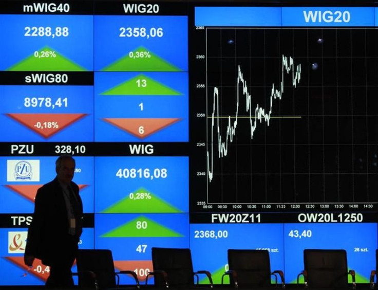 A man walks in front of the WIG20 index screen at the Warsaw Stock Exchange