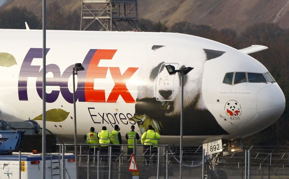 Airport workers watch as the FedEx Panda Express aircraft carrying two giant pandas taxis along the runway at Edinburgh airport in Scotland