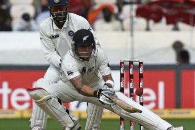 New Zealand's McCullum plays a shot as India's captain Dhoni watches in Hyderabad.