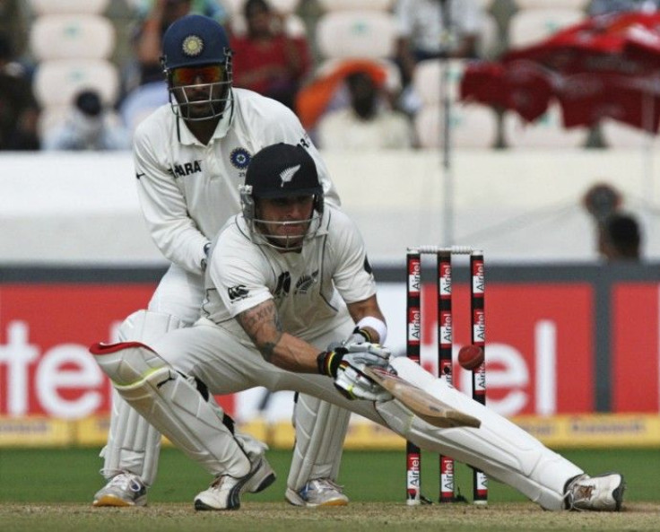 New Zealand's McCullum plays a shot as India's captain Dhoni watches in Hyderabad.