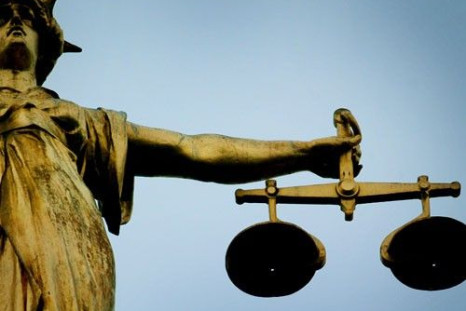 A statue holding the scales of justice is seen on top of the Old Bailey in London