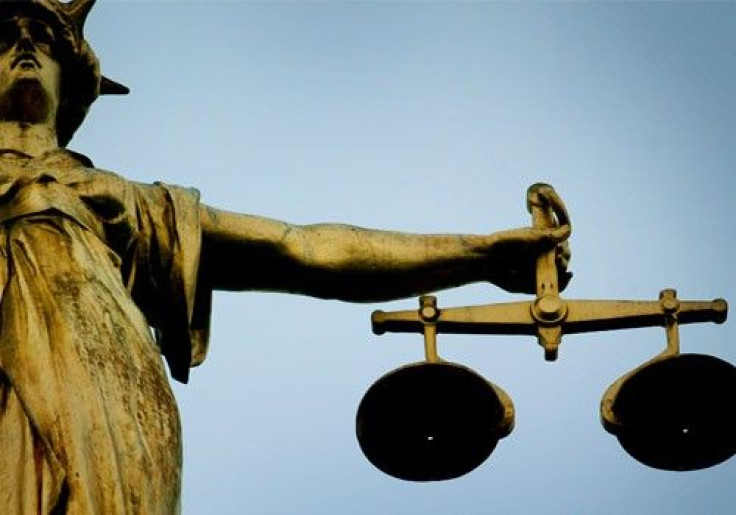A statue holding the scales of justice is seen on top of the Old Bailey in London