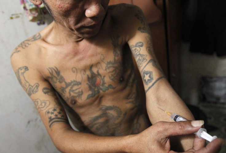 A Man , injects a syringe filled with heroin in his rented room in Hanoi