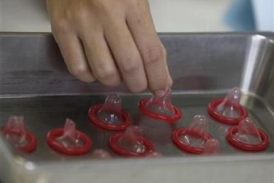 A health official inspects a condom at the Department of Medical Sciences laboratory in Nonthaburi province, on the outskirts of Bangkok September 27, 2010.