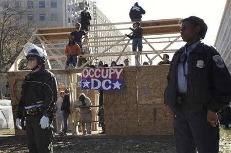 Police officers stand around a structure built the night before by Occupy DC protesters on McPherson Square in Washington