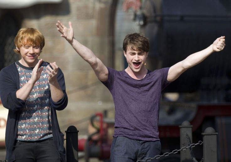 Radcliffe and Grint cheer with fans gathered for the grand opening for The Wizarding World of Harry Potter at the Universal Studio Resort in Orlando