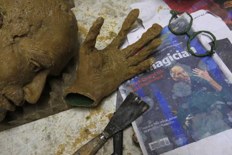 Parts of wax model for new bronze statue of late Apple co-founder Steve Jobs are seen near magazine cover with picture of Jobs in studio of Hungarian sculptor Toth in Budapest