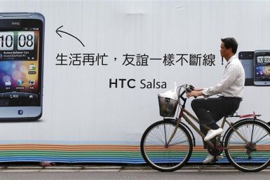 A man cycles past a HTC advertisement in Taipei