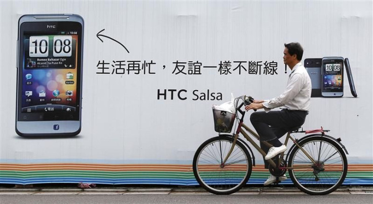 A man cycles past a HTC advertisement in Taipei
