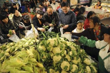 Customers select vegetables at a market in Hefei, Anhui province
