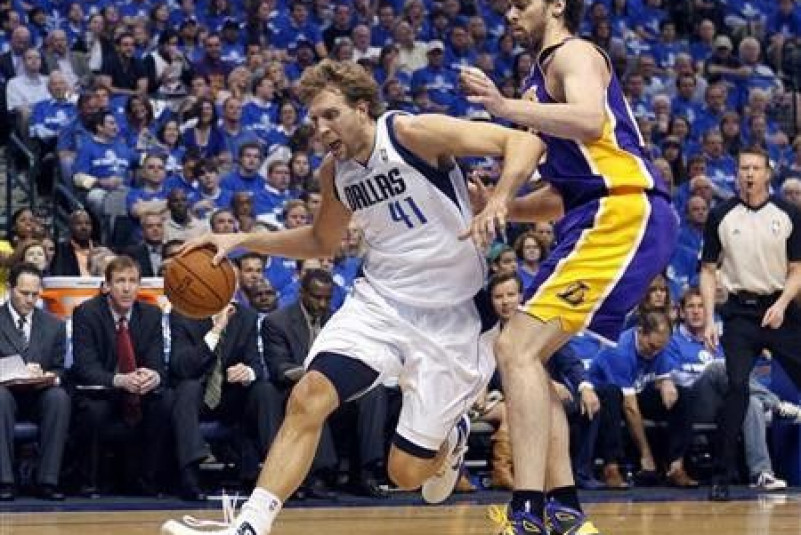 Dallas Mavericks power forward Dirk Nowitzki (L) drives the ball around Los Angeles Lakers power forward Pau Gasol in the first quarter during Game 3 of the NBA Western Conference semi-final basketball playoff in Dallas, Texas