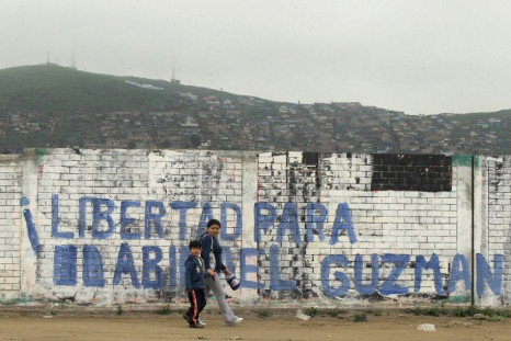 People walk in front of a sign that reads &#039;Freedom for Abimael Guzman&#039; in a shantytown of Villa El Salvador in Lima