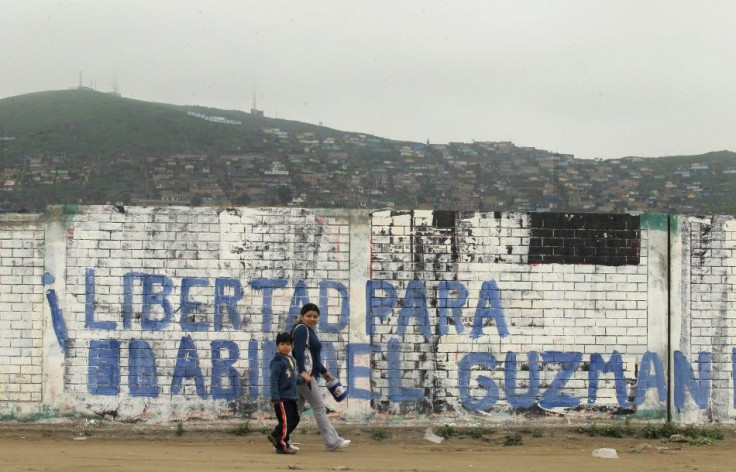 People walk in front of a sign that reads &#039;Freedom for Abimael Guzman&#039; in a shantytown of Villa El Salvador in Lima