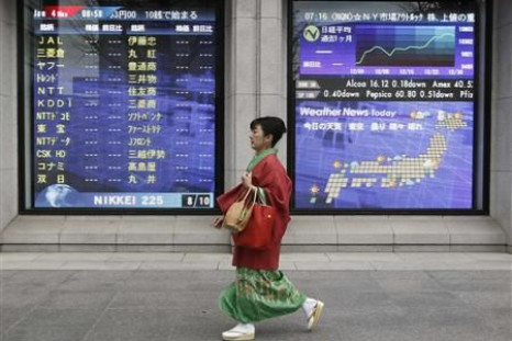 Woman in kimono walks past a stock quotation board outside a brokerage in Tokyo
