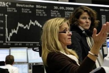 Traders react in front of the DAX board at the Frankfurt stock exchange September 30, 2008. 