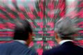 Japanese businessmen look closely at stock prices in Tokyo