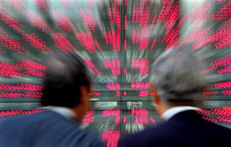 Japanese businessmen look closely at stock prices in Tokyo