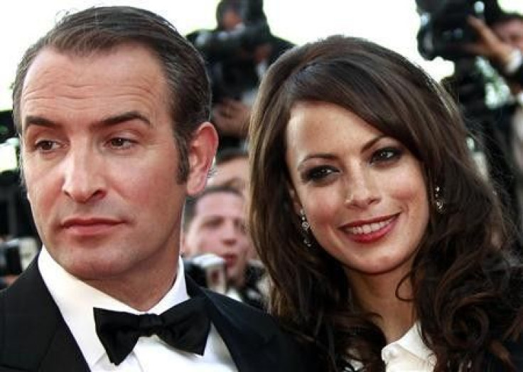 Cast members Jean Dujardin (L) and Berenice Bejo pose as they arrive on the red carpet for the screening of the film &#039;&#039;The Artist&#039;&#039; by director Michel Hazanavicius in competition at the 64th Cannes Film Festival