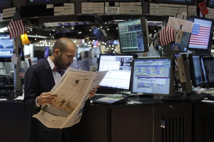 A trader reads a newspaper on the floor of the New York Stock Exchange in New York