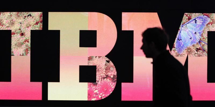 A man passes by an illuminated IBM logo at the CeBIT computer fair in Hanover