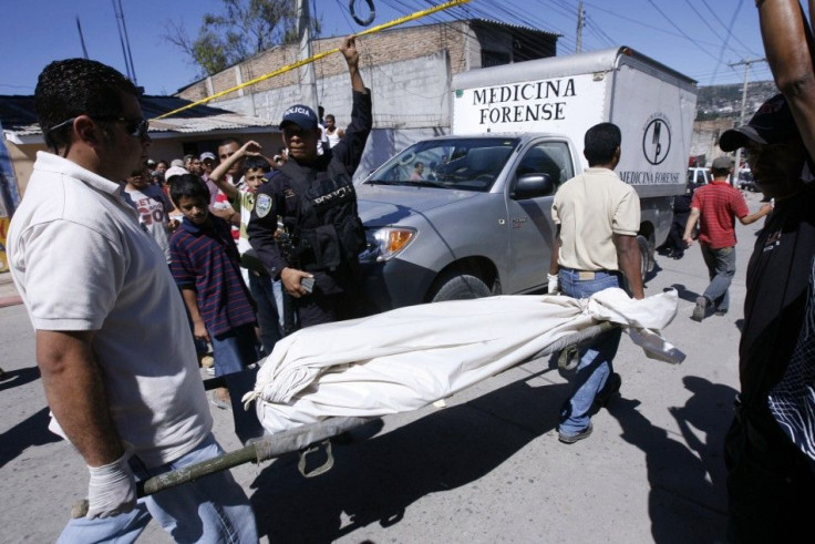 Forensic workers carry the body of journalist Luz Marina Paz, shot dead in her car together with her driver, in Tegucigalpa