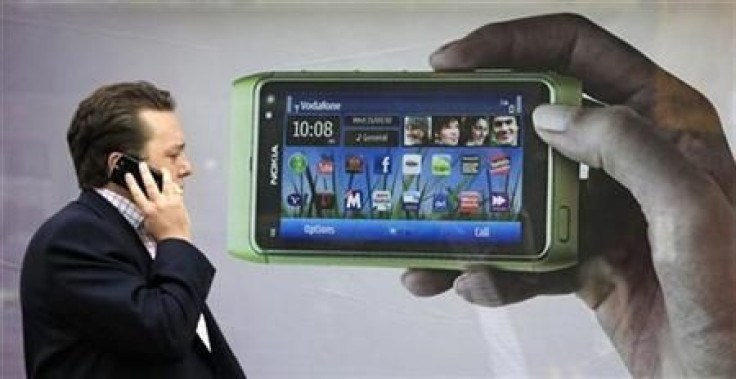 A man talks on his mobile phone as he walks past an advertisment for the new Nokia N8 on Oxford Street in London