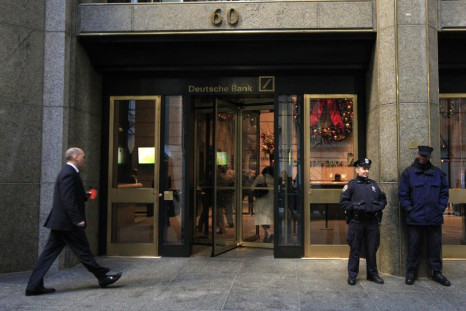A New York City Police Officer stands beside a security officer at the entrance of a Deutsche Bank office in New York