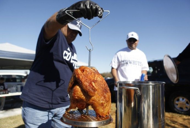 Mike Damian (L) pulls his Thanksgiving day turkey out of the frier before the start of an NFL football game between the Dallas Cowboys and Oakland Raiders in Arlington, Texas 