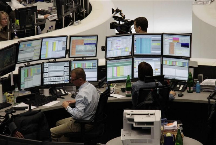Traders are pictured at their desks at the Frankfurt stock exchange