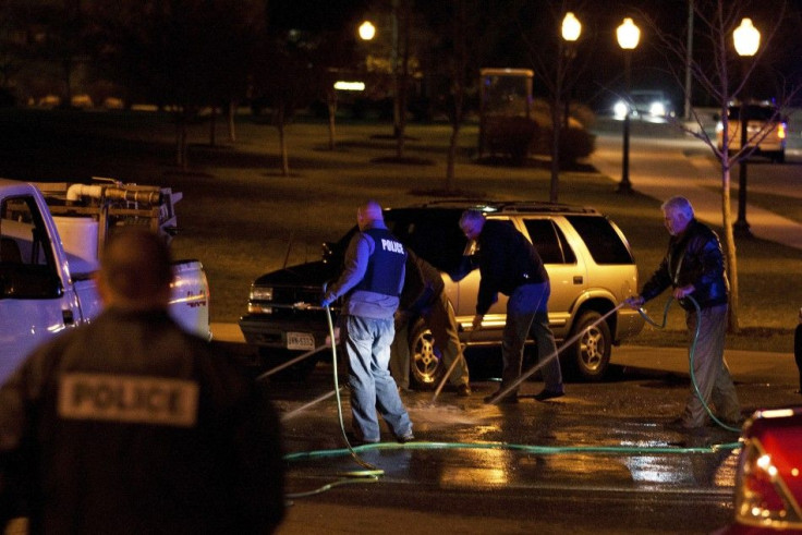 Law enforcement officers work to clean the road at the site where a Virginia Tech police officer was shot and killed at Virginia Tech University Blacksburg, Virginia