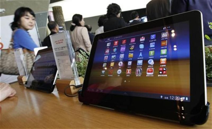Visitors walk past Samsung Electronics&#039; Galaxy Tab 10.1 tablets on display in Seoul