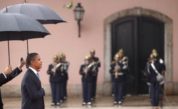 U.S. President Barack Obama and Portugal's President Anibal Cavaco Silva (partially hidden) are protected by umbrellas during an arrival ceremony at the Presidential Palace before the start of the NATO summit in Lisbon November 19, 2010. 