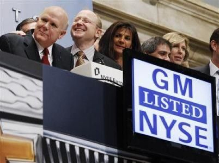 General Motors CEO Dan Akerson (L) smiles with others before ringing the opening bell of the New York Stock Exchange November 18, 2010.