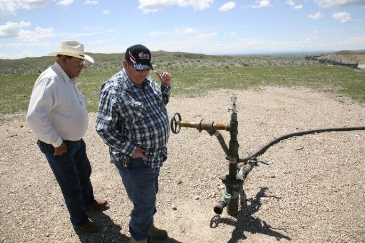 Two workers look at a gas well on the Crow Nation reservation near Crow Agency