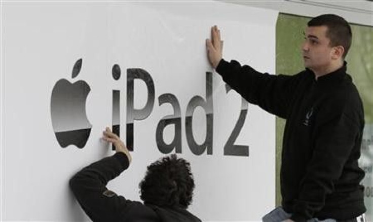 Workers stick-up a banner advertising the new iPad 2 at a computer store in Berlin