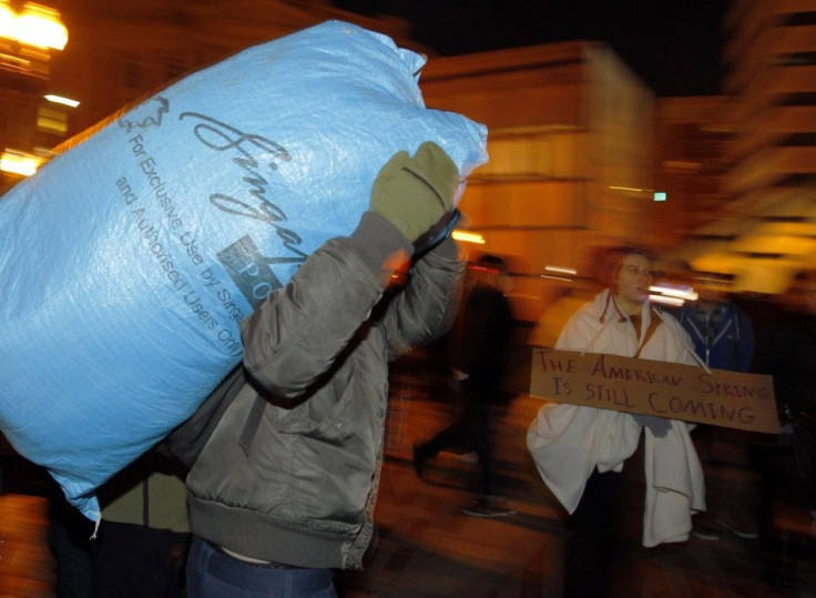 An Occupy Boston protester carries away a bag of belongings before a midnight deadline set by Boston Mayor Tom Menino for the group to leave its encampment in the city on Thursday December 8, 2011.