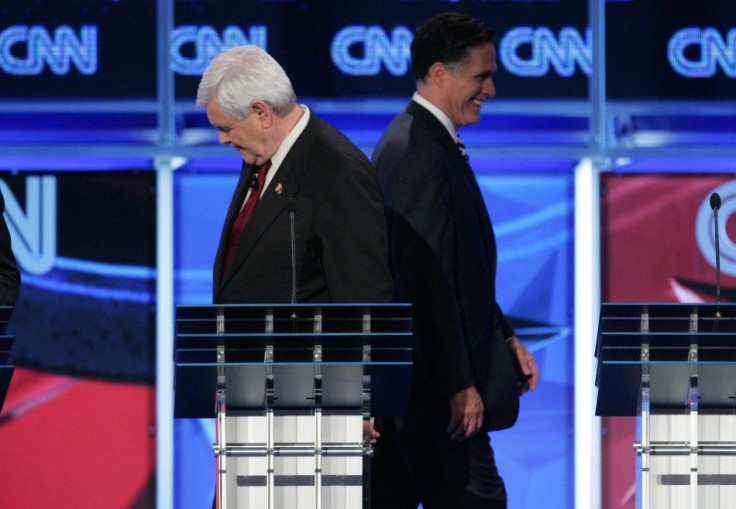 Former U.S. Speaker of the House Newt Gingrich, left, and former Massachusetts Gov. Mitt Romney are headed in different directions during a break in the CNN GOP National Security debate in Washington on Nov. 22.