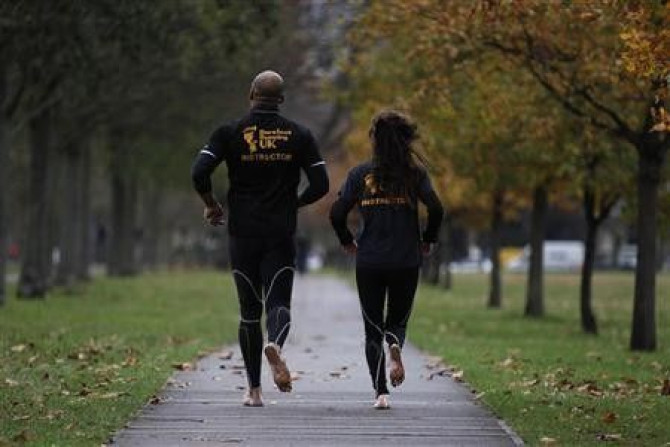 David Robinson (L) and Anna Toombs run barefoot in a park in south London December 1, 2011.