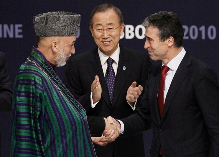 Afghanistan's President Hamid Karzai (L) and NATO Secretary General Anders Fogh Rasmussen (R) shake hands in front of U.N. Secretary General Ban Ki-moon after signing accords during the NATO Summit in Lisbon November 20, 2010. 
