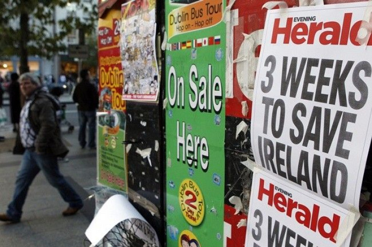 A man walks past newspaper headlines posted on a news stand on O'Connell street, Dublin, November 19, 2010. A financial aid plan to help Ireland cope with its battered banks will be unveiled next week, EU sources said on Friday, but experts warned a rescu