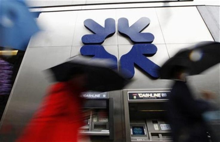 Morning commuters rush past a branch of RBS in London