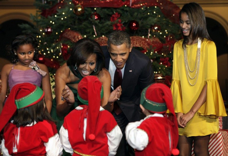 U.S. President Barack Obama, first lady Michelle Obama and their daughters Sasha (L) and Malia greet children, dressed as elves, at the &quot;Christmas in Washington&quot; celebration at the National Building Museum in Washington