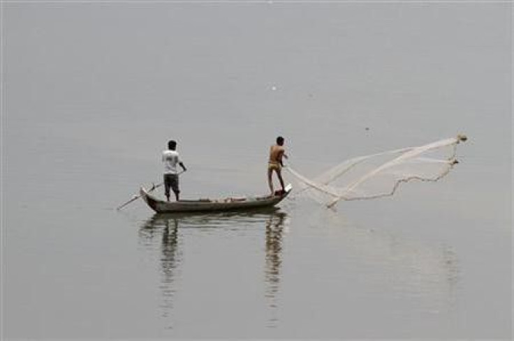 Cambodian fishermen cast their net into the Mekong River outside Phnom Penh April 19, 2011.