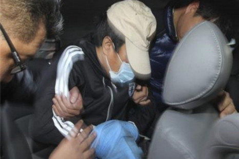 Policemen take the Chinese captain (C) involved in a stabbing incident to a car to transport him from a hospital to a police station in Incheon, west of Seoul December 12, 2011