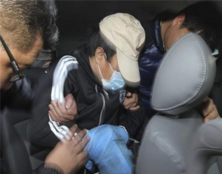 Policemen take the Chinese captain (C) involved in a stabbing incident to a car to transport him from a hospital to a police station in Incheon, west of Seoul December 12, 2011