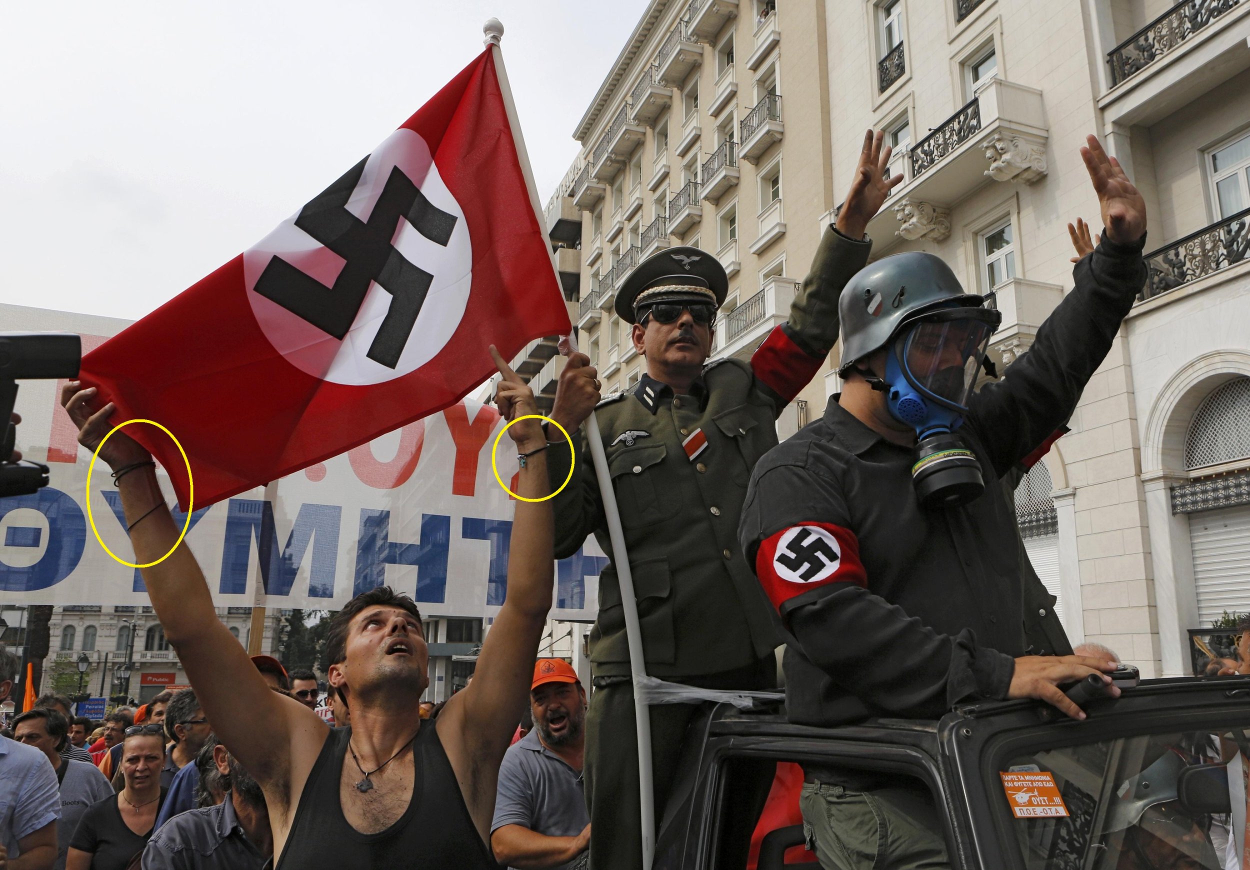 Demonstrators mock Angela Merkel during the German chancellors visit to Athens on October 9. A man holding up a Nazi flag shows he came to the protest in style.